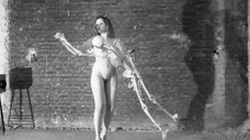 Голая женщина танцует со скелетом